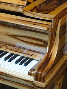 Een glanzende piano van licht hout