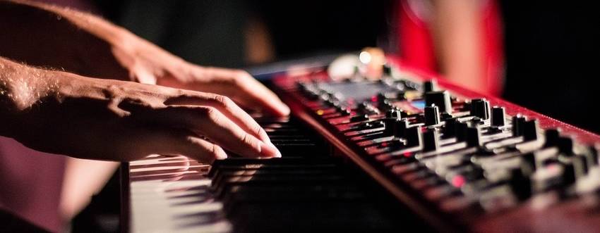 Twee handen die een stage piano aan het bespelen zijn