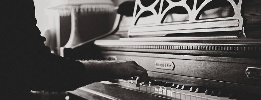Iemand die op een oude akoestische piano aan het spelen is
