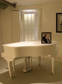 Een witte piano in een ruimte met een lijst er op