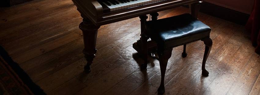 Een pianokruk die achter een piano staat opgesteld