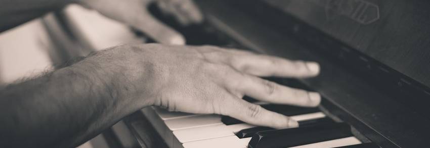 Twee handen die een piano bespelen